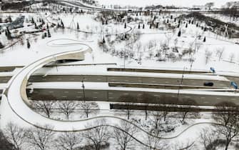 epa09017089 An aerial photo made with a drone shows the snow-covered PB Bridge in Millennium Park after an overnight snowfall left more than 18 inches (45.72cm) on the ground and roadways in Chicago, Illinois, USA, 16 February 2021. Much of the US has been in the grip of winter storms that have sent temperatures plummeting, closed major airports, and caused power outages to millions of people.  EPA/TANNEN MAURY