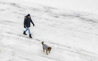 epa09017058 An aerial photo made with a drone shows a man walking his dog in a park after an overnight snowfall left more than 18 inches (45.72C) on the ground and roadways in Winnetka, Illinois, USA, 16 February 2021. Much of the US has been in the grip of winter storms that have sent temperatures plummeting, closed major airports, and caused power outages to millions of people.  EPA/TANNEN MAURY