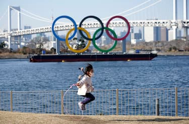 epa09003394 A young girl jumps a rope in front of a giant Olympic rings monument at Odaiba Marine Park in Tokyo, Japan, 11 February 2021. Tokyo 2020 Olympic Games Organising Committee President Yoshiro Mori is to step down following the turmoil caused by the sexist remarks he made on 03 February during a Japanese Olympic Committee meeting.  EPA/FRANCK ROBICHON