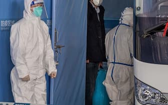 TOPSHOT-CHINA-HEALTH-VIRUS TOPSHOT - Vladimir G. Dedkov (C), a member of the World Health Organization (WHO) team investigating the origins of the Covid-19 pandemic, boards a bus following the team's arrival at a cordoned-off section in the international arrivals area at the airport in Wuhan on January 14, 2021. (Photo by NICOLAS ASFOURI / AFP)