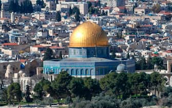 Mask-clad Palestinians, unable to reach the Al-Aqsa mosque compound amidst strengthened restriction due to the coronavirus, perform Friday prayers at the Mount of Olives overlooking the compound in the Old City of Jerusalem, on January 22, 2021. (Photo by AHMAD GHARABLI / AFP)