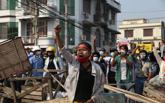 epaselect epa09041832 Demonstrators gesture at riot police behind makeshift barricades during a protest against the military coup in Mandalay, Myanmar, 28 February 2021. Security forces intensified their use of force to crack down on anti-coup demonstrations following weeks of unrest since the 01 February military coup.  EPA/KAUNG ZAW HEIN