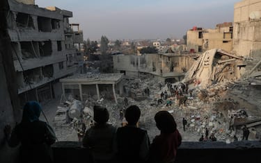 epa07078111 Children look out from their destroyed home as White Helmets volunteers search for survivors after several air strikes destroyed civil buildings in Hamoria city, al-Ghouta, Syria, 09 January 2018. The White Helmets volunteers pulled out more than 15 survivors, and at least 17 people got killed in the air strikes in the city, while a total of at least 27 people got killed on the day in the eastern Ghouta region.  EPA/MOHAMMED BADRA