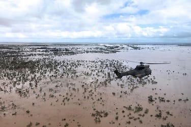TOPSHOT - An Oryx helicopter from the SANDF (South African National Defence Forces) flies during an air relief drop mission over the flooded area around Beira, central Mozambique, on March 20, 2019. - International aid agencies raced on March 20 to rescue survivors and meet spiralling humanitarian needs in three impoverished countries battered by one of the worst storms to hit southern Africa in decades. Five days after tropical cyclone Idai cut a swathe through Mozambique, Zimbabwe and Malawi, the confirmed death toll stood at more than 300 and hundreds of thousands of lives were at risk, officials said. (Photo by MARYKE VERMAAK / AFP)        (Photo credit should read MARYKE VERMAAK/AFP via Getty Images)