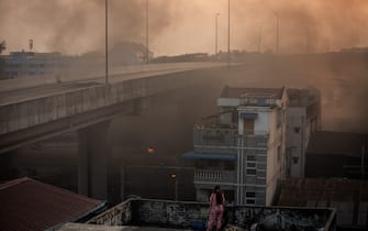 A woman gazing at the surrounding haze with smoke from fire in the streets following Myanmar military announcing a martial law for six townships in Yangon and attacked residents and protesters with rubber bullets, live ammunition, tear gas and stun bombs in response to anti military coup protesters. The death toll since military coup rises to 189. (Photo by Theint Mon Soe / SOPA Images/Sipa USA)