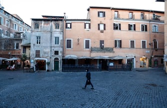 People walk in the streets of the semi-deserted Trastevere district on the first day of the entry into force of the new measures against the Covid-19 pandemic adopted by the government, in Rome, Italy, 15 March 2021. ANSA/ GIUSEPPE LAMI