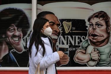 A man wearing a face mask walks by a closed pub in Dublin city center on the eve of St. Patrick's Day, during Level 5 Covid-19 lockdown. 
On Tuesday, 16 March 2021, in Dublin, Ireland. (Photo by Artur Widak/NurPhoto via Getty Images)