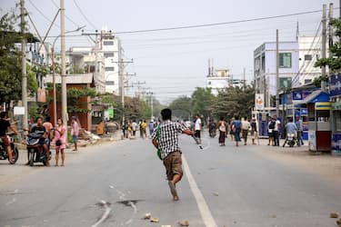 epa09087698 A man runs during a protest against the military coup in Mandalay, Myanmar, 21 March 2021. Anti-coup protests continued despite the intensifying violent crackdowns on demonstrators by security forces.  EPA/STRINGER