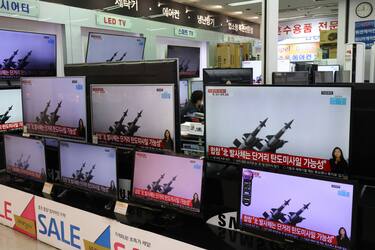 SEOUL, SOUTH KOREA - MARCH 25: A man wearing a face mask sits near TV screens showing a news program reporting about North Korea's missiles with file images at an electronic shop on March 25, 2021 in Seoul, South Korea. North Korea fired what appeared to be two short-range ballistic missiles into the East Sea, the South Korea's Joint Chiefs of Staff (JCS) said. (Photo by Chung Sung-Jun/Getty Images)
