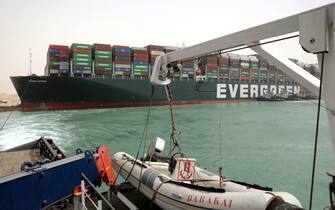 epa09095681 A handout photo made available by the Suez Canal Authority, shows the Ever Given container ship in the Suez Canal, Egypt, 25 March 2021. the Ever Given, a large container ship ran aground in the Suez Canal on 23 March, blocking passage of other ships and causing a traffic jam for cargo vessels.  The head of the Suez Canal Authority announced on 25 March that "the navigation through the Suez Canal is temporarily suspended" until the floatation of the Ever Given is completed. Its floatation is being carried out by 8 large tugboats that are towing and pushing the grounding vessel.  EPA/SUEZ CANAL AUTHORITY/HO EDITORIAL USE ONLY NO SALES HANDOUT EDITORIAL USE ONLY/NO SALES