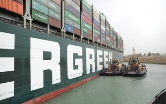 epa09095675 A handout photo made available by the Suez Canal Authority, shows the Ever Given container ship in the Suez Canal, Egypt, 25 March 2021. the Ever Given, a large container ship ran aground in the Suez Canal on 23 March, blocking passage of other ships and causing a traffic jam for cargo vessels.  The head of the Suez Canal Authority announced on 25 March that "the navigation through the Suez Canal is temporarily suspended" until the floatation of the Ever Given is completed. Its floatation is being carried out by 8 large tugboats that are towing and pushing the grounding vessel.  EPA/SUEZ CANAL AUTHORITY/HO EDITORIAL USE ONLY NO SALES HANDOUT EDITORIAL USE ONLY/NO SALES