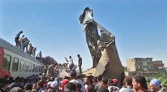 This screengrab provided by AFPTV shows people gathered around the wreckage of two trains that collided in the Tahta district of Sohag province, some 460 kms (285 miles) south of the Egyptian capital Cairo, reportedly killing at least 32 people and injuring scores of others, on March 26, 2021. - Egypt has been plagued with deadly train accidents in recent years that have been widely blamed on inadequate infrastructure and poor maintenance. (Photo by - / AFP) (Photo by -/AFP via Getty Images)