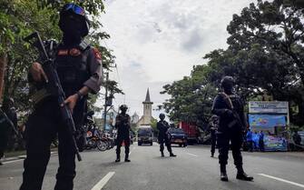 epa09102596 Police officers stand guard near the Sacred Heart of Jesus Cathedral in the aftermath of an explosion in Makassar, South Sulawesi, Indonesia, 28 March 2021. At least nine people were wounded as a suspected suicide bomber blew themselves up outside the church on Palm Sunday. The number of casualties was still unclear.  EPA/DAENG MANSUR