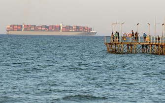 epa06958960 Egyptians enjoy the sea as a cargo ship crosses the Gulf of Suez towards the Red Sea at El Sokhna beach in Suez, Egypt, 130 km east of Cairo, Egypt, 19 August 2018  EPA/KHALED ELFIQI