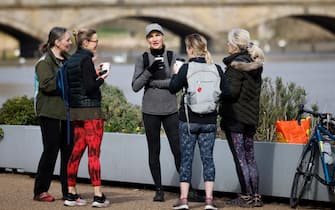 A small group chat over cups of coffee in Hyde Park in London on March 29, 2021, as England's third Covid-19 lockdown restrictions ease, allowing groups of up to six people to meet outside. - England began to further ease its coronavirus lockdown on Monday, spurred by rapid vaccinations, but governments in the rest of Europe struggled to contain Covid-19 surges. (Photo by Tolga Akmen / AFP)
