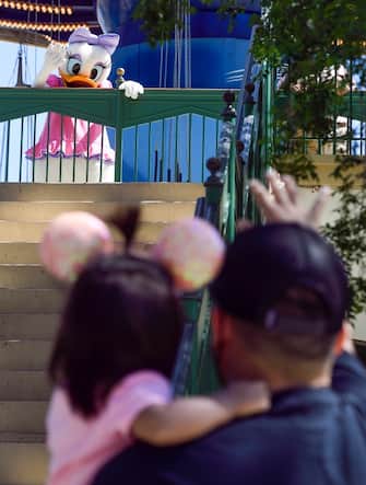 ANAHEIM, CA - MARCH 18: Sarena Carlin, 1, holds on to her father, Christopher Carlin, as they meet Daisy Duck  during Touch of Disney at Disney California Adventure in Anaheim, CA, on Thursday, March 18, 2021. Character meet-and-greets are now distanced due to the COVID-19 outbreak. (Photo by Jeff Gritchen/MediaNews Group/Orange County Register via Getty Images)