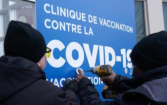 epa08883857 Workers set up signs at the first center to recive Covid-19 vaccine in Montreal, Canada, 14 December 2020. The first patients in Canada will be vaccinated there with the Pfizer BionNtech vaccine.  EPA/ANDRE PICHETTE