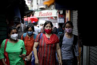 epa09116491 Indian commuters use face masks in a street in Kolkata, India, 05 April 2021. India recorded over 100,000 new coronavirus infections in the last 24 hours, the highest daily spike since September 2020 bringing the total infections to over 11 million people making the county the third highest in the world following the US and Brazil.  EPA/PIYAL ADHIKARY