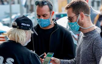 Attendees present their "green passes" (proof of being fully vaccinated against COVID-19 coronavirus disease) as they arrive at Bloomfield Stadium in the Israeli Mediterranean coastal city of Tel Aviv on March 5, 2021, before attending a "green pass concert" for vaccinated seniors, organised by the Tel Aviv municipality. - Israel took a step towards normalcy on Sunday, re-opening a raft of businesses and services from pandemic lockdowns, but with some only available to fully vaccinated "green pass" holders. Nearly three million people, almost a third of Israel's population, have received the two recommended doses of the Pfizer/BioNTech coronavirus vaccine, the world's quickest inoculation pace per capita. (Photo by JACK GUEZ / AFP) (Photo by JACK GUEZ/AFP via Getty Images)