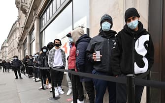 Shoppers queue outside a Nike store in central London as coronavirus restrictions are eased across the country on April 12, 2021. (Photo by Glyn KIRK / AFP) (Photo by GLYN KIRK/AFP via Getty Images)