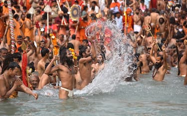 epa09130359 Indian holy men or Naga Sadhu along with the other pilgrims take the holy dip in Ganga river during the Kumbh Mela royal bath m(Sacred Hindu Pilgrimage) at Haridwar, Uttarakhand, India, 12 April 2021. Thousands of pilgrims are gathering and taking holy dip in Kumbh Mela that is a mass Hindu pilgrimage which occurs after every twelve years and rotates among four locations Prayag (Allahabad) at the confluence of the Ganga and Yamuna and mythical Saraswati river, Haridwar along the Ganga river, Ujjain along the Kshipra river and Nashik along the Godavari river. EPA/IDREES MOHAMMED