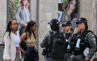 Israeli security officers talk to women on a street in Jerusalem, on April 18, 2021, after Israeli authorities announced that face masks for COVID-19 prevention were no longer required outdoors. - With over half the population fully vaccinated in one of the world's fastest anti-COVID19 inoculation campaigns, Israel's coronavirus caseload tumbled from some 10,000 new infections per day as recently as mid-January, to around 200 cases a day, prompting an announcement by the Health Ministry on April 15 that face masks are no longer compulsory outdoors. (Photo by menahem kahana / AFP) (Photo by MENAHEM KAHANA/AFP via Getty Images)