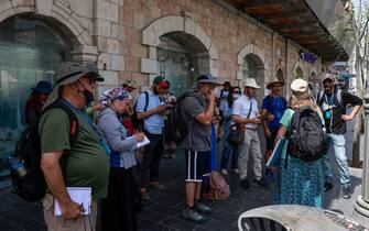 Tourists gather on a street in Jerusalem, on April 18, 2021, after Israeli authorities announced that face masks for COVID-19 prevention were no longer required outdoors. - With over half the population fully vaccinated in one of the world's fastest anti-COVID19 inoculation campaigns, Israel's coronavirus caseload tumbled from some 10,000 new infections per day as recently as mid-January, to around 200 cases a day, prompting an announcement by the Health Ministry on April 15 that face masks are no longer compulsory outdoors. (Photo by menahem kahana / AFP) (Photo by MENAHEM KAHANA/AFP via Getty Images)
