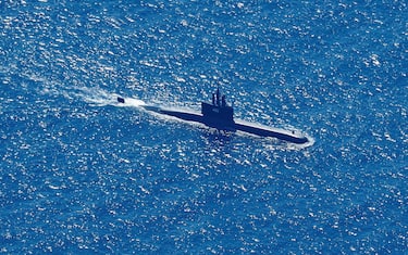epa09152692 An aerial photo taken from a maritime patrol aircraft of 800 Air Squadron of the 2nd Air Wing of Naval Aviation Center (PUSPENERBAL), shows Indonesian Navy submarine KRI Alugoro sailing on a search mission for KRI Nanggala, a Navy submarine that went missing during a naval exercise, in the waters off Bali Island, Indonesia, 22 April 2021. The German-made submarine was reported missing on 21 April 2021 near the island of Bali with 53 people on board while preparing to conduct a torpedo drill, the the Indonesian National Armed Forces said.  EPA/ERIC IRENG