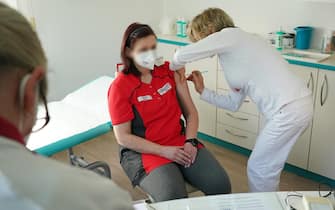 epa09048647   Doctor Claudia Richartz (R) inoculates a health care worker against COVID-19 with the AstraZeneca vaccine at her private practice as part of a pilot project in the state of Brandenburg during the coronavirus pandemic in Senftenberg, Germany, 03 March 2021. Several German states are allowing vaccinations against COVID-19 to begin in a limited number of private medical practices with the aim of expanding venues that offer the vaccines beyond the current mass vaccination centers. While Germany's vaccination rollout has been hampered by less than anticipated shipments of vaccine, the volume of shipments has begun increasing, leading to higher weekly numbers of vaccinations.  EPA/Sean Gallup / POOL