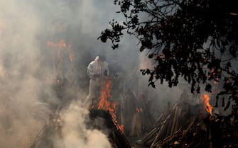 A relative stands next to the burning funeral pyres of those who died due to the coronavirus disease (COVID-19), at Ghazipur cremation ground in New Delhi.
In India the highest single-day spike in coronavirus infection. The report recorded 352,991 new Covid-19 cases and 2,812 deaths in the last 24 hours amid an oxygen crisis. - Naveen Sharma / SOPA Images//SOPAIMAGES_08380019/2104270904/Credit:SOPA Images/SIPA/2104270907