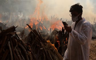 A relative stands next to the burning funeral pyres of those who died due to the coronavirus disease (COVID-19), at Ghazipur cremation ground in New Delhi.
In India the highest single-day spike in coronavirus infection. The report recorded 352,991 new Covid-19 cases and 2,812 deaths in the last 24 hours amid an oxygen crisis. - Naveen Sharma / SOPA Images//SOPAIMAGES_08380021/2104270904/Credit:SOPA Images/SIPA/2104270907