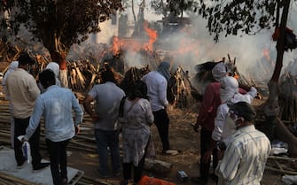 Family members look on as several funeral pyres of those patients who died of COVID-19 disease burn up during the mass cremation at Ghazipur cremation ground in New Delhi.
In India the highest single-day spike in coronavirus infection. The report recorded 352,991 new Covid-19 cases and 2,812 deaths in the last 24 hours amid an oxygen crisis. - Naveen Sharma / SOPA Images//SOPAIMAGES_08380024/2104270905/Credit:SOPA Images/SIPA/2104270907