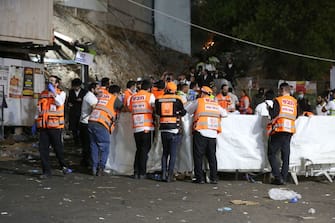 Emergency workers gather at the scene after dozens of people were killed and others injured after a grandstand collapsed in Meron, Israel, where tens of thousands of people were gathered to celebrate the festival of Lag Ba'omer at the site in northern Israel early on April 30, 2021. - Dozens of people were killed in a stampede at a Jewish pilgrimage site in the north of Israel on early on April 30, rescue services said.  Tens of thousands of Jews were participating in the annual pilgrimage on Thursday, for the feast of Lag BaOmer. But after midnight, a grandstand collapsed, triggering scenes of panic. - Israel OUT (Photo by David COHEN / JINI PIX / AFP) / Israel OUT (Photo by DAVID COHEN/JINI PIX/AFP via Getty Images)