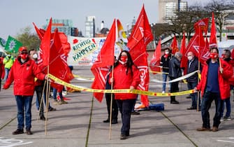 01 May 2021, Hamburg: Participants of the main rally of the German Trade Union Confederation (DGB) on Labour Day wave flags of the GEW trade union at the Hamburg fish market. Photo: Axel Heimken/dpa