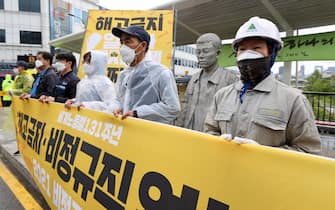 epa09170985 Members of an activist group hold a press conference to call for a ban on dismissals of workers and measures against job insecurity, as they mark Labor Day in central Seoul, South Korea, 01 May 2021.  EPA/YONHAP SOUTH KOREA OUT