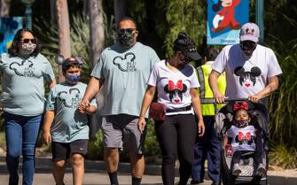 ANAHEIM, CA - APRIL 30: People enter Disneyland Park as it reopens for the first time since the COVID 19 pandemic forced the park to shut down last year on April 30, 2021 in Anaheim, California. California saw some of the highest infection rates in the nation over the winter but now enjoys some of the lowest. Los Angeles County, for example, is now expected to move from the orange tier of the states economic reopening system based on COVID-19 metrics to the least restrictive yellow tier, which would allow greater reopening freedoms, as early as next week.  (Photo by David McNew/Getty Images)
