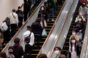 epa09167502 Commuters stand on escalators at Shinjuku business and shopping district in Tokyo, Japan, 29 April 2021. Tokyo recorded its highest coronavirus infections cases since January 2021 with 1,027 new cases. The country is affected by a surge of COVID-19 cases less than three months before from the opening of the Tokyo Olympic Games.  EPA/FRANCK ROBICHON