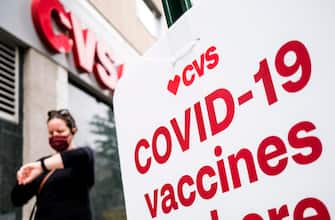 epa09175951 A person walks past a sign for COVID-19 vaccines outside of a CVS pharmacy, one of two national pharmacy chains providing vaccination shots around the country, in the Brooklyn borough of New York, New York, USA, 03 May 2021. According to data from the United States  Centers for Disease Control and Prevention there were reportedly 182,874 wasted vaccine doses, much of made by Pfizer which requires being stored at extreme low temperatures, as of late March. Over half of the reported waste has been attributed to CVS.  EPA/JUSTIN LANE