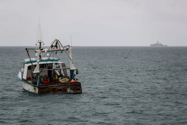 HMS Tamar (REAR), a Batch 2 river-class offshore patrol vessel of the British Navy, is watched by a fishing boat as it patrols the waters off the British island of Jersey on May 6, 2021. - Around 50 French fishing boats gathered to protest at the main port of the UK island of Jersey on May 6, amid fresh tensions between France and Britain over fishing. The boats massed in front of the port of Saint Helier to draw attention to what they see as unfair restrictions on their ability to fish in UK waters after Brexit, an AFP photographer at the scene said. (Photo by Sameer Al-DOUMY / AFP) (Photo by SAMEER AL-DOUMY/AFP via Getty Images)