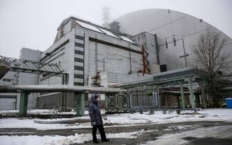 epa05685630 A worker stands next to the new protective shelter over the remains of the nuclear reactor Unit 4, at Chernobyl nuclear power plant, in Chernobyl, Ukraine, 22 December 2016. The new mobile structure will secure the affected fourth reactor. The shelter is over 105 metres tall and weighs 36,000 tons. The explosion of Unit 4 of the Chernobyl nuclear power plant in the early hours of 26 April 1986 is still regarded the biggest accident in the history of nuclear power generation.  EPA/ROMAN PILIPEY