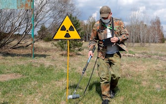 epa09152965 A dosimetrist walks past the radiation sign at the Chernobyl zone, Ukraine, 22 April 2021. Ukraine will mark the 35th anniversary of Chernobyl tragedy on 26 April 2021. The explosion of reactor 4 of the Chernobyl nuclear power plant in the early hours of 26 April 1986 is still regarded as the worst nuclear disaster no date.  EPA/SERGEY DOLZHENKO