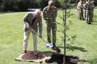 WINDSOR, ENGLAND - MAY 05: Prince Charles, Prince of Wales helps plant a tree next to Commanding Officer, Lieutenant Colonel Henry Llewelyn-Usher, during a visit to the Welsh Guards at Combermere Barracks on May 5, 2021 in Windsor, England. (Photo by Peter Cziborra - WPA Pool/Getty Images)