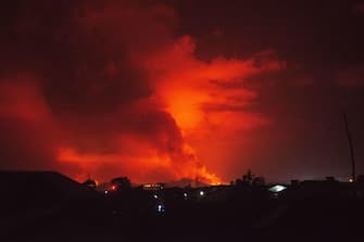 This general view taken on May 22, 2021 in Goma in the East of the Democratic Republic of Congo shows flame spewing from the Nyiragongo volcano. - The famous Nyiragongo volcano, near the city of Goma, in the east of the Democratic Republic of the Congo (DRC), suddenly became active on Saturday evening, an AFP correspondent noted. Strong emanations of glowing light coming out of the crater were visible from Goma, while a smell of sulfur was perceptible in the city, located on the southern flank of the volcano, on the shores of Lake Kivu, he noted. (Photo by Moses Sawasawa / AFP)