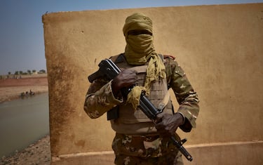 A Malian soldier stands posing by the river bank in Konna on March 20, 2021 as the Malian Prime Minister and his delegation visit the town in central Mali to attend the inauguration of the new river port, which was destroyed by bombing during the war in 2013. - Located some 50 kilometres north of Mopti, the town of Konna used to be a key area for fishing activities in central Mali. (Photo by MICHELE CATTANI / AFP) (Photo by MICHELE CATTANI/AFP via Getty Images)
