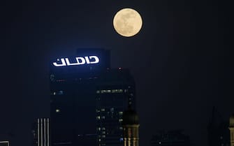 epa09229846 The Super Moon called the 'Flower Moon' rises in the sky of the Gulf emirate of Dubai, United Arab Emirates, 26 May 2021. The UAE will not be among the world's countries which are witnessing a blood super moon and total lunar eclipse like the US, Australia, South America and Eastern Asia.  EPA/ALI HAIDER