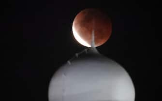 epa09228945 Lunar eclipse is observed over dome of Al Azhar Mosque in Jakarta, Indonesia, 26 May 2021. Total Lunar Eclipse of Blood Moon on 26 May 2021 or the 'super flower blood moon' starts around 4:45 pm to 7:52 pm and can be seen from everywhere in Indonesia.  EPA/Bagus Indahono