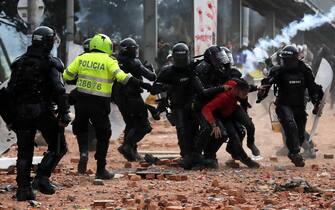 epa09234412 Members of the Mobile Anti-Riot Squad (ESMAD) detain a protester during a day of protests, in Madrid, a municipality near Bogota, Colombia, 28 May 2021. The protests against the Colombian government mark a month with calls for new demonstrations and the country plunged into uncertainty due to the lack of proposals to solve this crisis, marked by violence and roadblocks in some regions.  EPA/Mauricio Duenas Castaneda