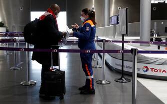 Un viaggiatore parla con un membro della Protezione Civile mentre arriva per un test COVID-19 all'aeroporto Charles de Gaulle di Parigi a Roissy vicino a Parigi, Francia, 05 febbraio 2021