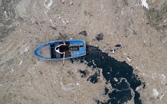 epa09247098 An aerial photo made with a drone shows a fisherman in a boat on the Marmara sea covered by sea snot in Istanbul, Turkey, 04 June 2021. Because of global heating, blanket of mucus-like substance in Marmara sea increasing day by day threatens fishing industry and the environment. Sea snot is formed as a result of the proliferation of microalgae called phytoplankton in the sea. The biggest reason for this is that the water temperature in the Marmara sea is 2.5 degrees above the average of the last 40 years.  EPA/ERDEM SAHIN