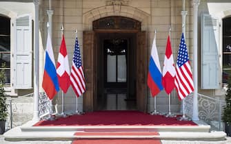 epa09273034 Flags of the US, Russia and Switzerland photographed in front of the entrance of the villa La Grange, one day prior to the US - Russia summit in Geneva, Switzerland, 15 June 2021. The meeting between US President Joe Biden and Russian President Vladimir Putin is scheduled in Geneva for 16 June 2021.  EPA/PETER KLAUNZER